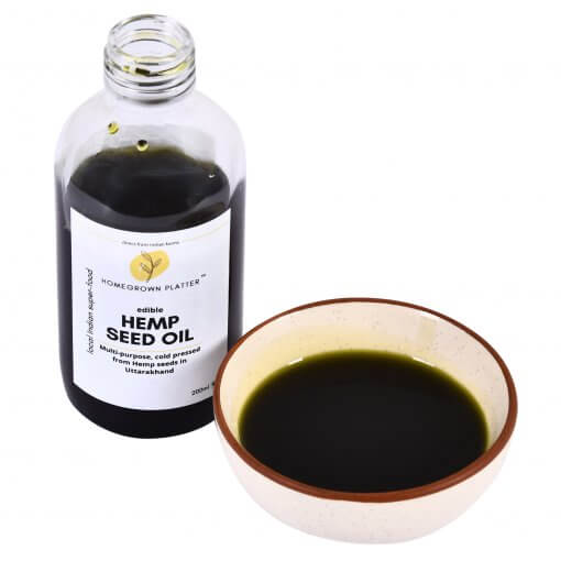 A 200ml bottle of cold pressed hemp seed oil and a bowl containing some of this oil.